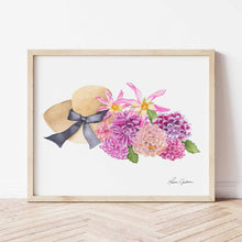Load image into Gallery viewer, tan sunhat with black bow beside a bunch of pink, coral, fuscia, and purple dahlias with green leaves
