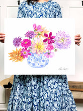 Load image into Gallery viewer, woman holding picture of Blue and White vase filled with bright dahlia flowers of different varieties. Colors used: purple, lilac, magenta, pink, yellow, royal blue, light blue, orange
