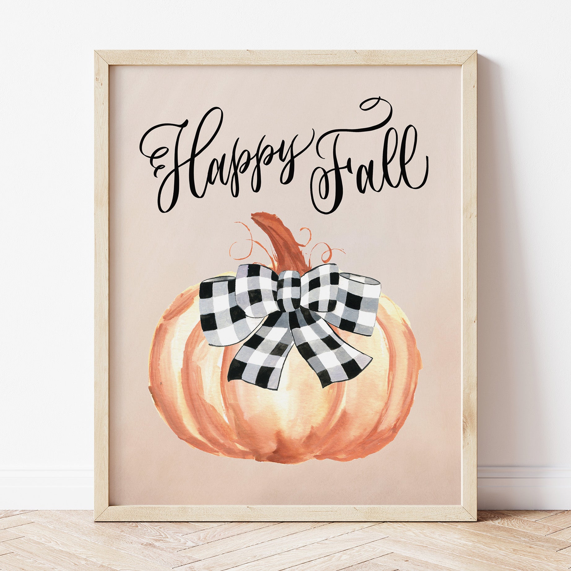 Happy Fall Art Print with a painted burnt orange pumpkin topped with a buffalo plaid bow. "Happy Fall" is handlettered above the pumpkin artwork.