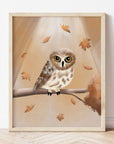 Art Print of a northern saw whet owl on a tree branch surrounded by fall leaves